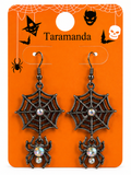 A pair of Halloween dangling earrings displayed on an orange retail card. The earrings have black spiderweb and spider motifs with iridescent rhinestone centers and hooks.