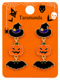 A pair of Halloween-themed dangle earrings displayed on an orange backing card. Each earring features a black witch hat with a purple band and gold star, a carved orange pumpkin, and a black bat.