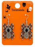Spider drop earrings with black and silver rhinestone detailing, displayed on an orange Halloween-themed card labeled 'Taramanda'.