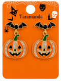 A pair of Halloween-themed bat and jack-o'-lantern earrings on an orange display card. The earrings feature black bat wings, black eyes, green stems, and orange pumpkin bodies decorated with clear rhinestones.