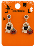 A pair of Halloween-themed dangle earrings displayed on an orange retail card. The earrings feature ghost-shaped charms covered in white faux pearls with black centers, attached to gold rings, and are paired with pumpkin charms decorated with red, gold, and multicolor rhinestones.