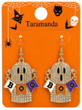 A pair of gold-tone dangle earrings with rhinestone-covered ghost charms, black facial details, and small white, orange, and purple 'BOO' flag accents, displayed on an orange Halloween-themed card labeled Taramanda.